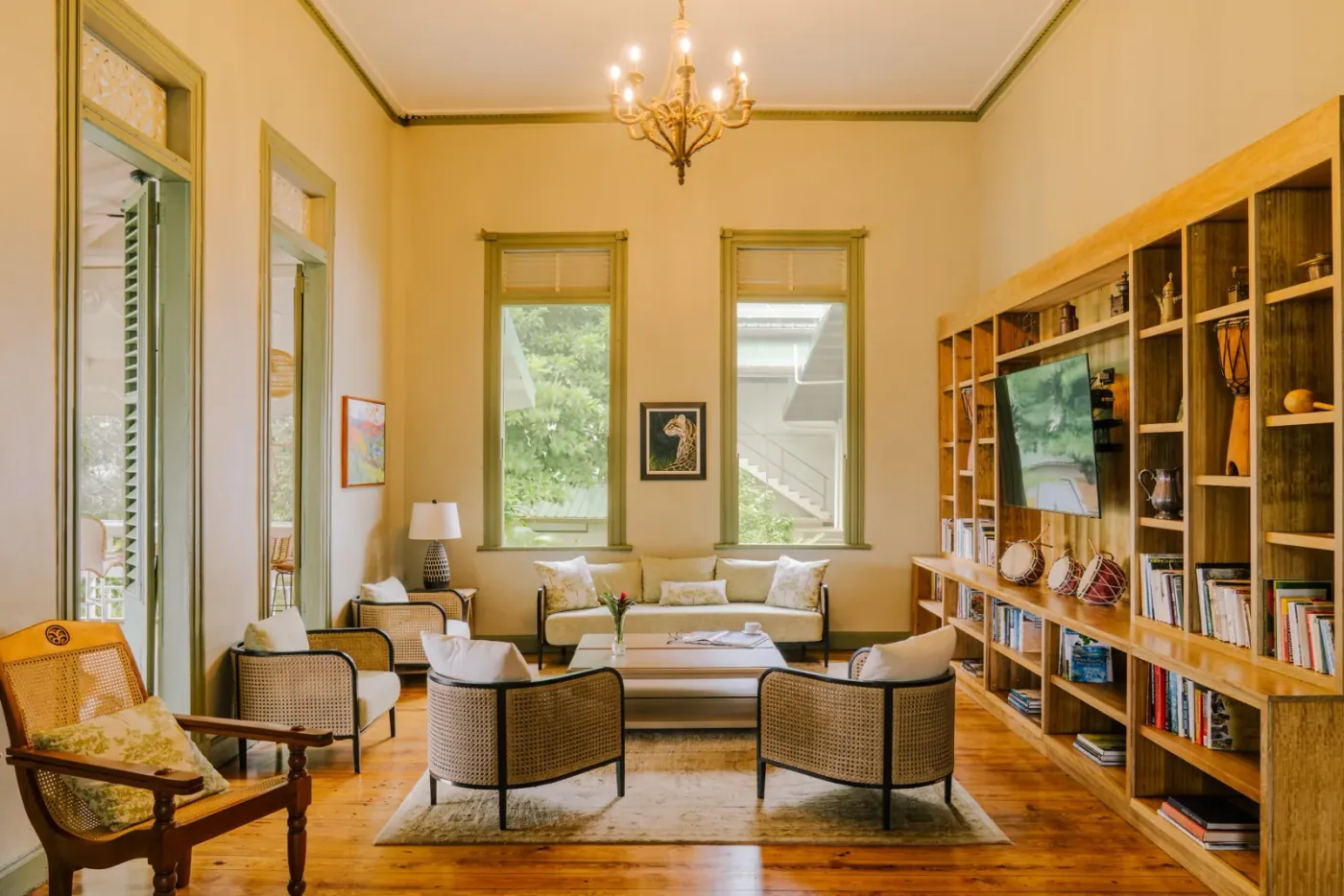 Salón histórico con biblioteca y muebles de mimbre