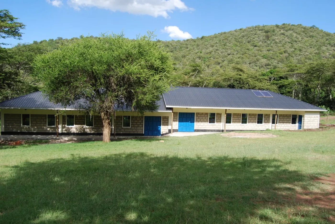 Edificio del colegio construido para la comunidad local, con paneles solares en el tejado