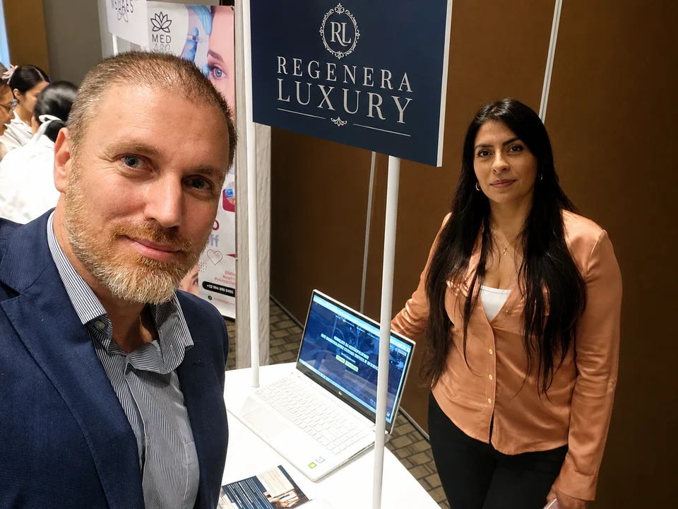 Lourdes Abad en un stand profesional en Cancún durante sus prácticas, junto a su mentor, Héctor de Castro